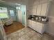 Kitchen area connecting to living room, featuring a breakfast bar and tile flooring, seamlessly blending living spaces at 2455 Finlandia Ln # 3, Clearwater, FL 33763