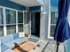 Comfortable balcony featuring a cozy seating area, a wooden table, and an umbrella at 247 Rex Pl # G, Madeira Beach, FL 33708