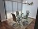 Inviting dining room featuring a glass table and chairs, with modern light fixture at 247 Rex Pl # G, Madeira Beach, FL 33708