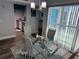 Contemporary dining room with a glass table, modern chairs, and stylish light fixture at 247 Rex Pl # G, Madeira Beach, FL 33708