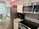 Well-equipped kitchen with stainless steel appliances, granite counters, and ample cabinet space at 247 Rex Pl # G, Madeira Beach, FL 33708