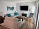 Stylish living room featuring neutral sofas, a large TV, and an elegant fireplace at 247 Rex Pl # G, Madeira Beach, FL 33708