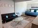 Open-concept living room with bed, futon, glass coffee table, and light-colored walls at 247 Rex Pl # G, Madeira Beach, FL 33708