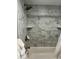 Shower/tub combination with bronze fixtures and marble-tiled walls at 247 Rex Pl # G, Madeira Beach, FL 33708