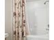 Bright bathroom featuring a shower-tub combination with decorative floral shower curtain at 2712 Conch Hollow Dr, Brandon, FL 33511