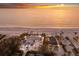 Stunning aerial view of beachfront property with private access to pristine sands and serene ocean waters at sunset at 3351 Gulf Of Mexico Dr, Longboat Key, FL 34228