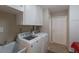 Functional laundry room with washer, dryer, and ample storage space at 3351 Gulf Of Mexico Dr, Longboat Key, FL 34228