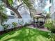 A view of the backyard with artificial turf and patio area, featuring outdoor seating and a gazebo at 4302 W San Pedro St, Tampa, FL 33629