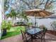 Backyard patio with a glass top table with seating and a large umbrella for shade at 4302 W San Pedro St, Tampa, FL 33629