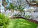 Landscaped backyard featuring an artificial lawn, palm trees and manicured shrubbery at 4302 W San Pedro St, Tampa, FL 33629