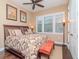 Cozy bedroom features a ceiling fan, three windows and an orange bench at the foot of the bed at 4302 W San Pedro St, Tampa, FL 33629