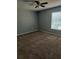 Bedroom with neutral gray walls, plush carpeting, ceiling fan, and a window letting in natural light at 4321 Winding River Way, Land O Lakes, FL 34639