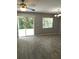 Open-concept living room with ceiling fan and sliding glass door to backyard at 4321 Winding River Way, Land O Lakes, FL 34639