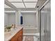 Bright bathroom featuring a double vanity, modern lighting, and a shower/tub combination with glass door at 4901 Lansing St Ne, St Petersburg, FL 33703