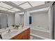 Bright bathroom showcasing dual sinks, a white tile backsplash, a soaking tub, and a skylight at 4901 Lansing St Ne, St Petersburg, FL 33703