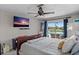 Bright bedroom featuring a ceiling fan, flatscreen TV, and sliding glass doors opening to outdoor pool area at 4901 Lansing St Ne, St Petersburg, FL 33703