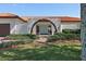 Welcoming home facade featuring a unique arched entry, lush landscaping, and a well-maintained lawn at 4901 Lansing St Ne, St Petersburg, FL 33703