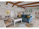 Open-concept living room with exposed wood beams and view into adjacent rooms at 4901 Lansing St Ne, St Petersburg, FL 33703
