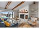 Cozy living room featuring a stone fireplace, wood beam ceiling, and views of the canal at 4901 Lansing St Ne, St Petersburg, FL 33703