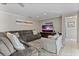 Bright living room featuring a comfortable couch, side chair, ceiling fan, and tv entertainment center at 4901 Lansing St Ne, St Petersburg, FL 33703
