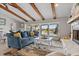 Bright living room with a stone fireplace, wood beams, and a view of the pool and patio at 4901 Lansing St Ne, St Petersburg, FL 33703