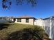 View of a partially shaded backyard and patio area, enclosed by a white vinyl fence at 4908 Wild Senna Blvd, Tampa, FL 33619