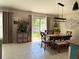 Bright dining area featuring a modern light fixture, dining table and chairs, and sliding glass doors to backyard at 4908 Wild Senna Blvd, Tampa, FL 33619
