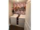 Functional laundry room featuring a washer, dryer, storage shelves, and floral wallpaper at 4908 Wild Senna Blvd, Tampa, FL 33619