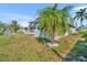 Landscaped backyard featuring a fenced-in area, mature palm trees, and a serene outdoor space for relaxation at 541 Ridgecrest Dr, Punta Gorda, FL 33982