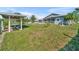Expansive backyard with lush green grass, tropical palms, and a covered boat lift, perfect for outdoor enjoyment at 541 Ridgecrest Dr, Punta Gorda, FL 33982