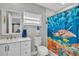 Bathroom features a white vanity and a tub-shower with a decorative sea turtle curtain at 541 Ridgecrest Dr, Punta Gorda, FL 33982