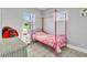 Bedroom with a pink metal canopy bed, neutral walls, and tile floors at 541 Ridgecrest Dr, Punta Gorda, FL 33982