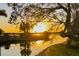 Picturesque sunset over the water, framed by trees; a tranquil and idyllic waterfront scene at 541 Ridgecrest Dr, Punta Gorda, FL 33982