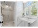 Bright bathroom featuring pedestal sink, a glass-enclosed shower, and nautical-themed wallpaper at 72 Adalia Ave, Tampa, FL 33606