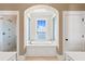 Elegant bathroom featuring a soaking tub with views, glass-enclosed shower, and refined finishes at 72 Adalia Ave, Tampa, FL 33606