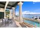 Covered patio with waterfront views, featuring a dining table and in-ground swimming pool at 72 Adalia Ave, Tampa, FL 33606