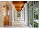 Elegant hallway featuring arched doorways, wood ceilings, and natural stone flooring at 72 Adalia Ave, Tampa, FL 33606