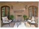 Covered patio with a brick fireplace, seating, and decorative lighting at 72 Adalia Ave, Tampa, FL 33606