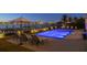 Gorgeous waterfront pool with dock, lounge chairs, lush landscaping, and a bay view at twilight at 72 Adalia Ave, Tampa, FL 33606