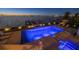 Beautiful waterfront pool and hot tub with bay view at night, complete with dock and lounge chairs at 72 Adalia Ave, Tampa, FL 33606