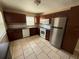 Beautiful kitchen featuring stainless steel appliances, dark wood cabinets, tile backsplash and a large tile floor at 7425 Riverbank Dr, New Port Richey, FL 34655