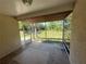 View of an empty screened porch overlooking a grassy, fenced yard with mature trees at 7425 Riverbank Dr, New Port Richey, FL 34655