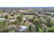 Scenic aerial shot of property with mature trees, lush landscaping, and surrounding landscape at 8523 Hamster Dr, Zephyrhills, FL 33540