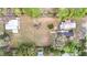 Expansive aerial view of property with lush landscaping, mature trees, and multiple structures on the land at 8523 Hamster Dr, Zephyrhills, FL 33540