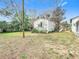 Exterior view of home showing the grassy yard with a small storage building at 8523 Hamster Dr, Zephyrhills, FL 33540