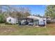 Modest single story home with a three-car carport and grassy front lawn at 8523 Hamster Dr, Zephyrhills, FL 33540