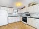 Kitchen featuring white cabinets, black oven and light wood laminate floors at 8523 Hamster Dr, Zephyrhills, FL 33540