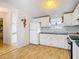 Kitchen with white appliances, cabinets, and floral wallpaper at 8523 Hamster Dr, Zephyrhills, FL 33540