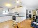 Kitchen featuring white cabinets, black oven and light wood laminate floors at 8523 Hamster Dr, Zephyrhills, FL 33540