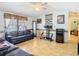 Living room featuring light wood floors, vintage wallpaper borders and outdated furnishings at 8523 Hamster Dr, Zephyrhills, FL 33540